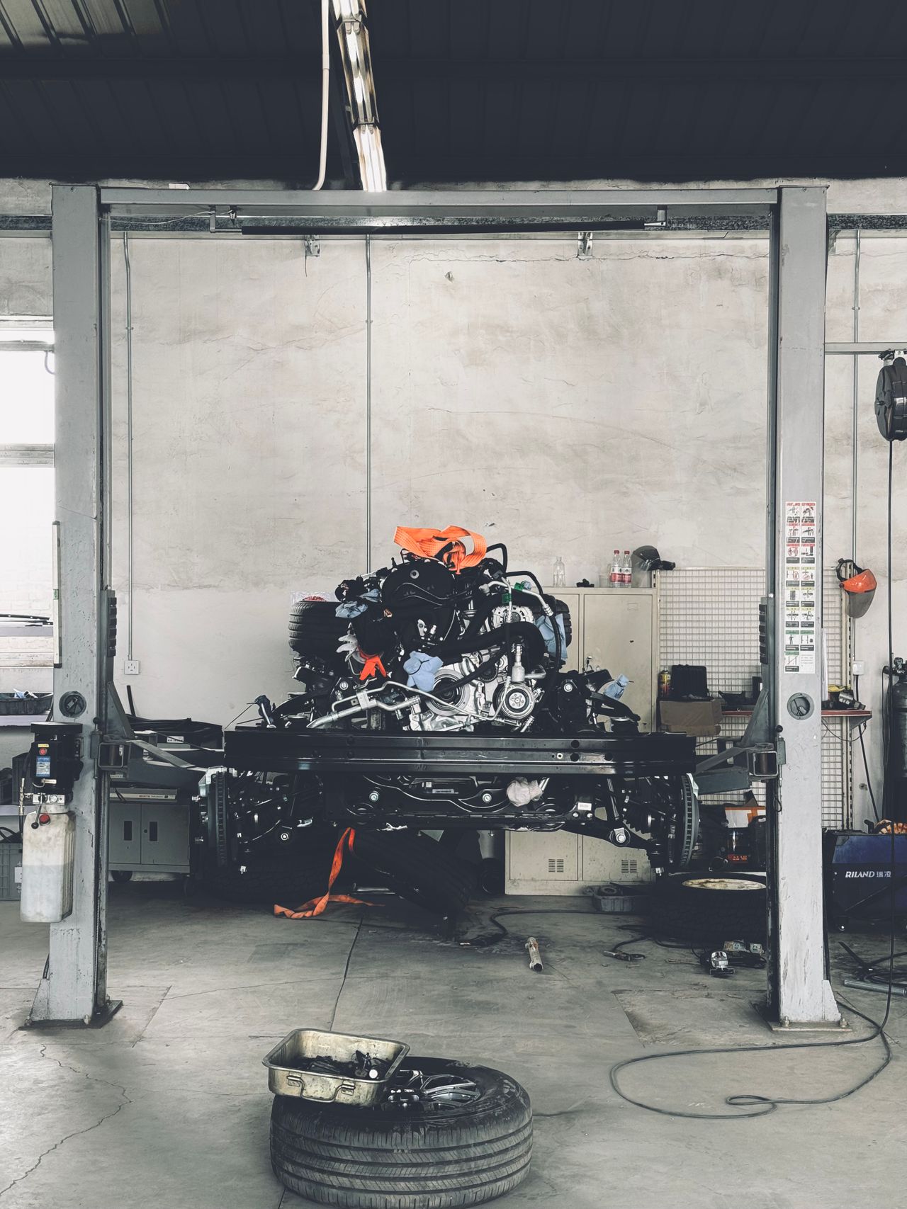 Detailing bay interior with a vehicle raised on a lift