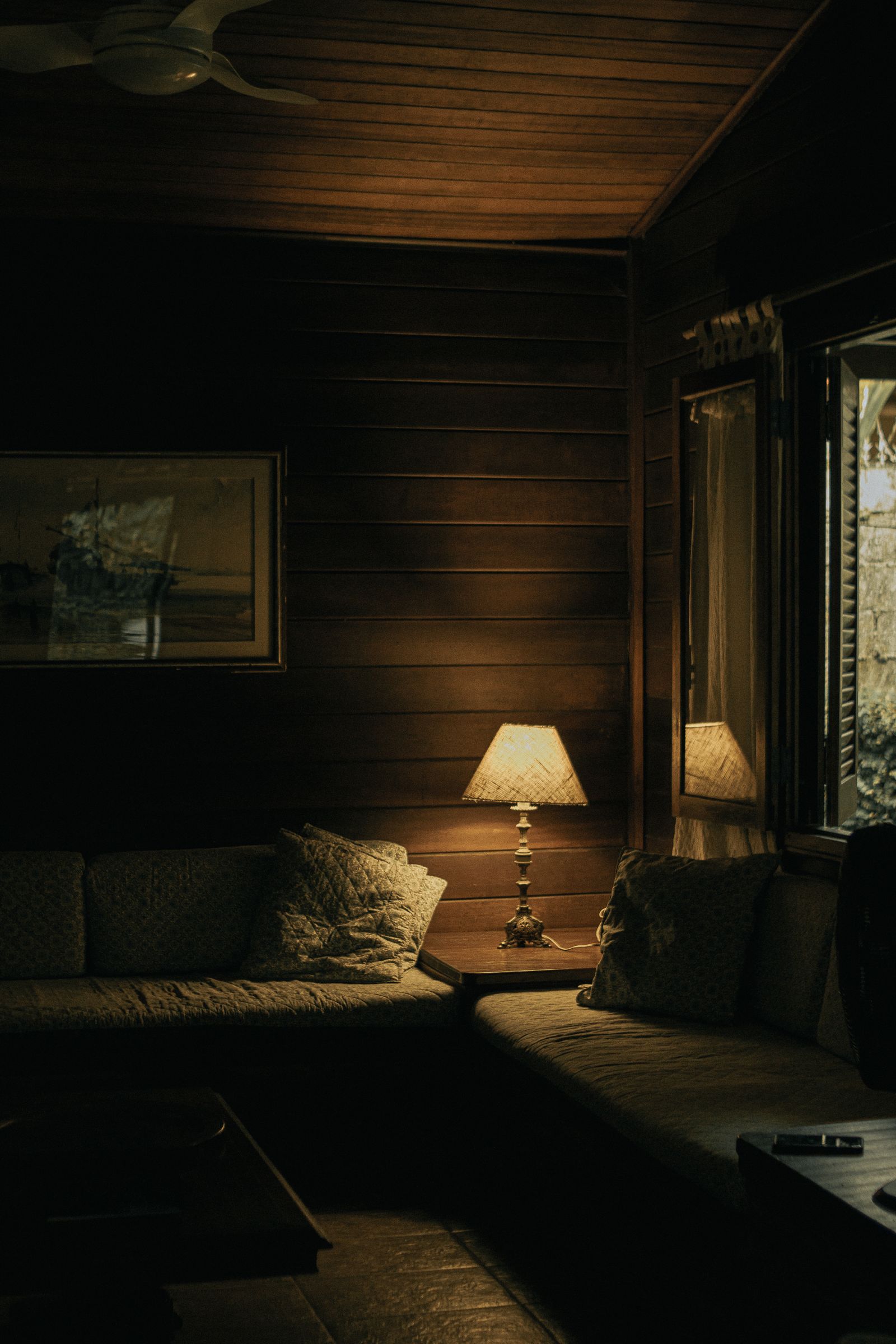 Cozy rustic cabin living room with warm lamp lighting and wooden interior