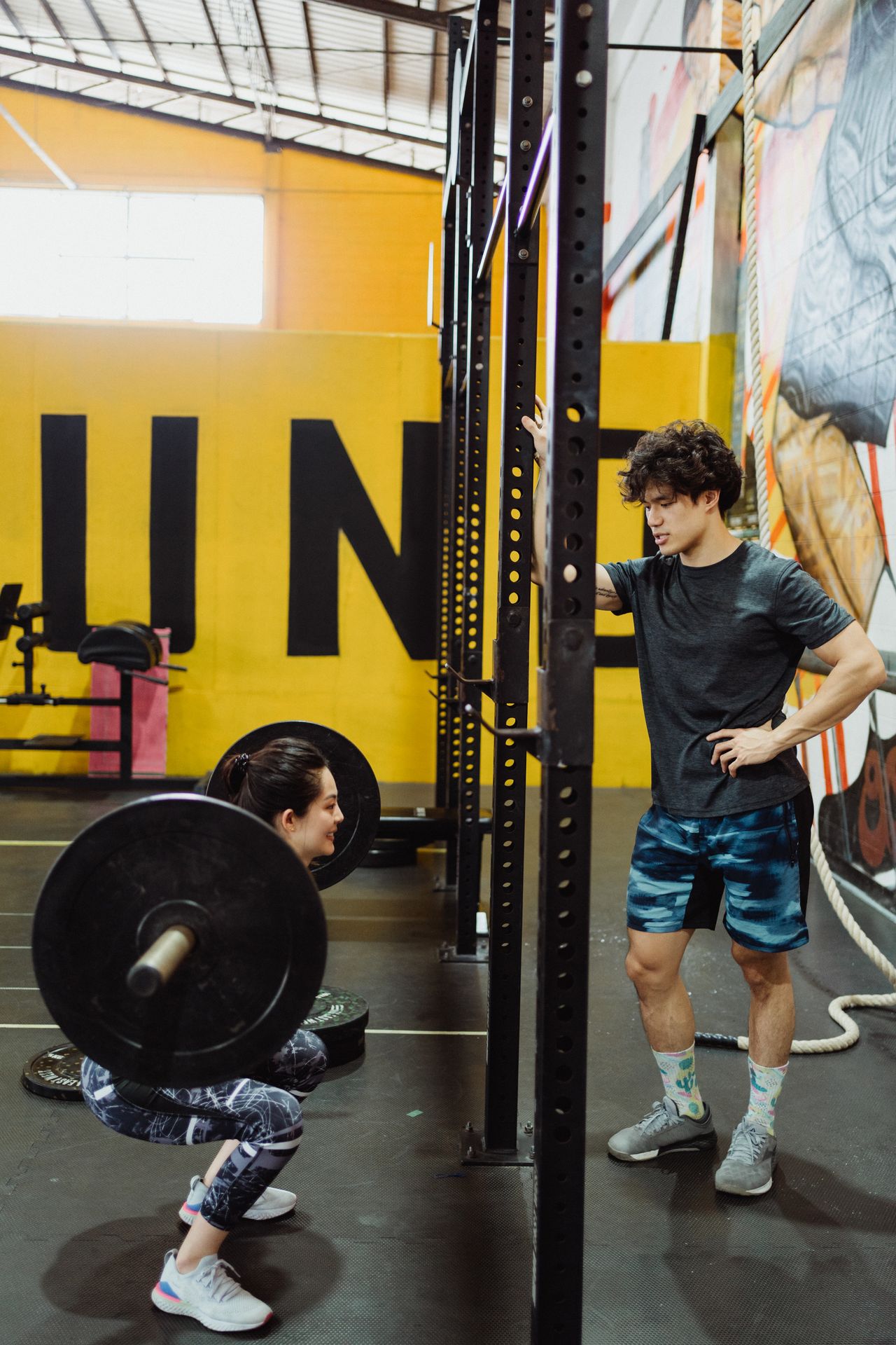 An athlete performing a barbell back squat during a strength training session