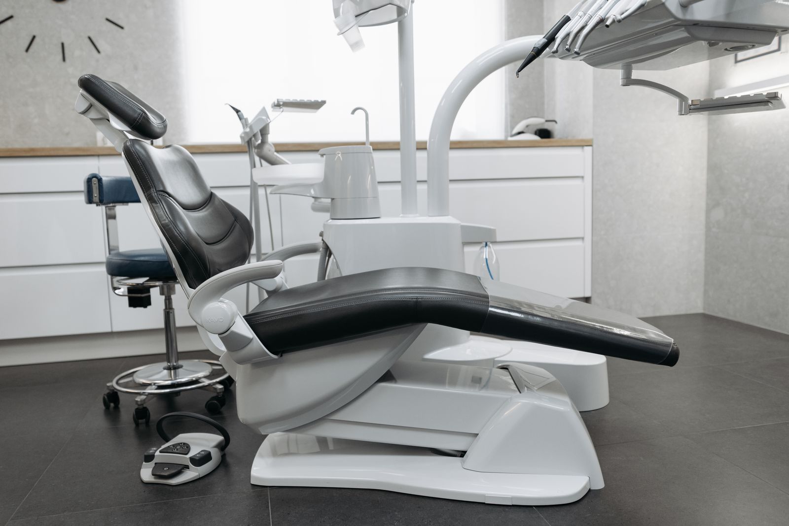 A calm, minimalist dental clinic room with a modern chair and soft natural light