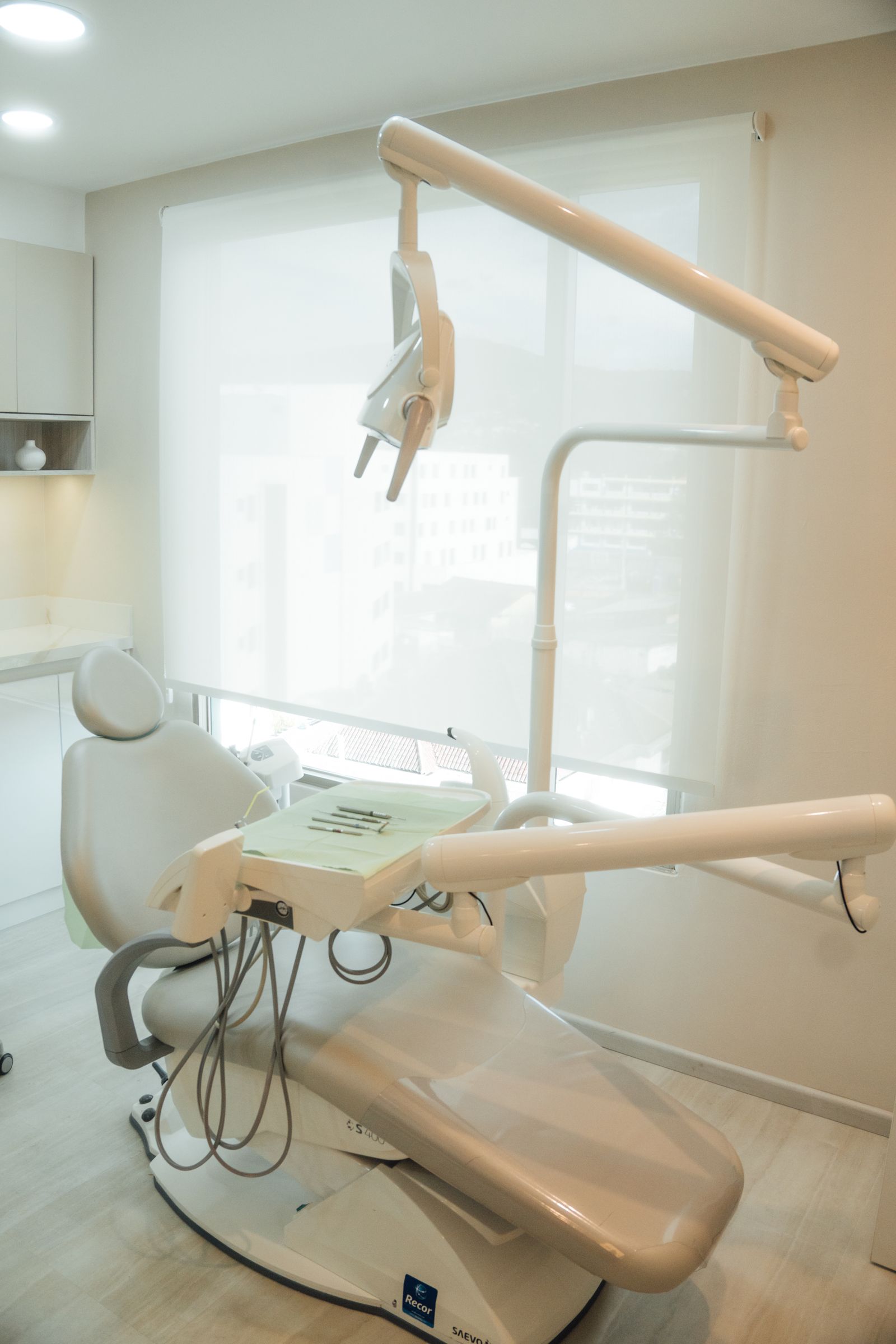 A bright, modern dental treatment room with a clean dental chair and equipment
