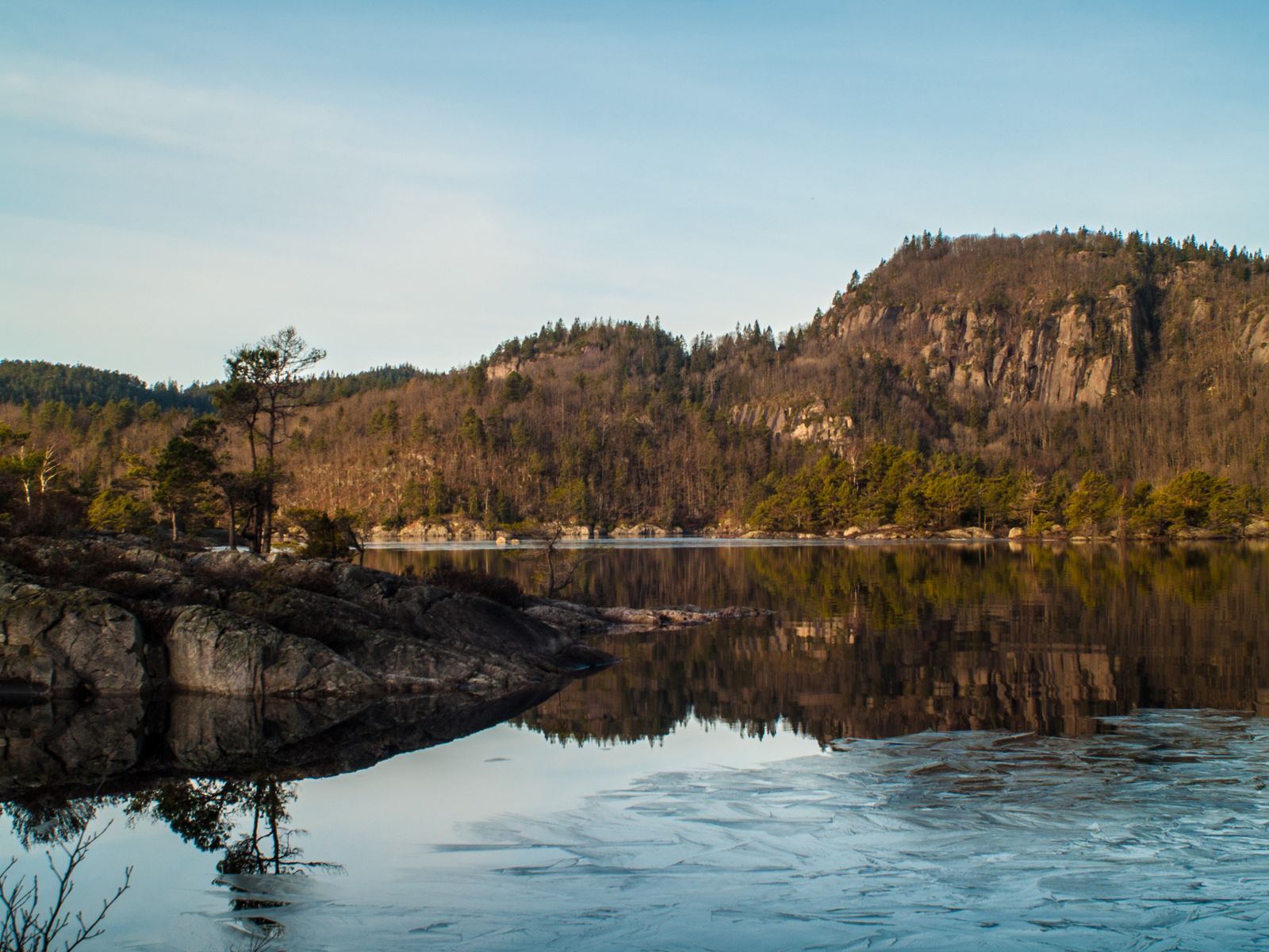 Mountain range and autumn forest reflected in the still surface of a calm lake