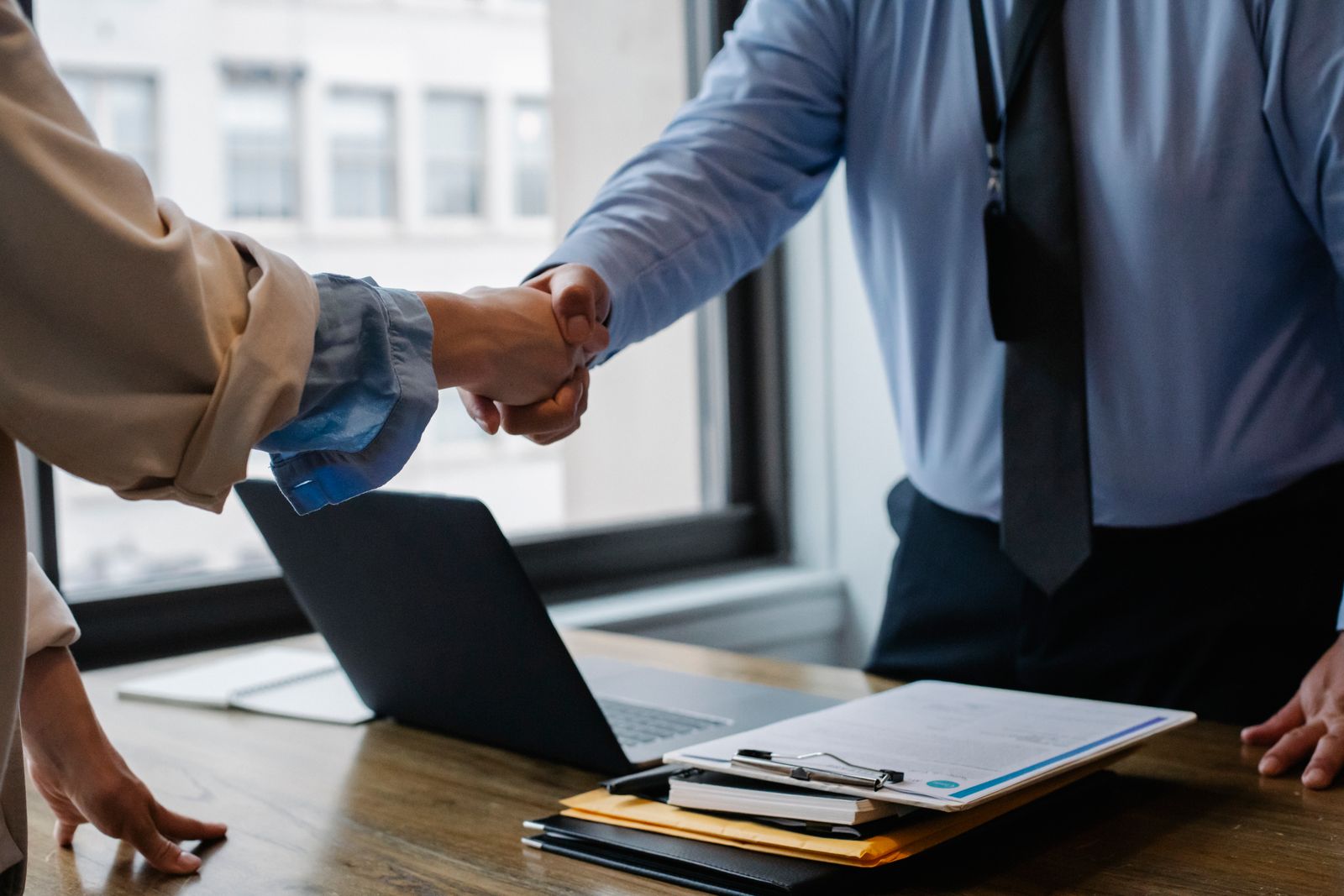 Two professionals shaking hands in a modern office