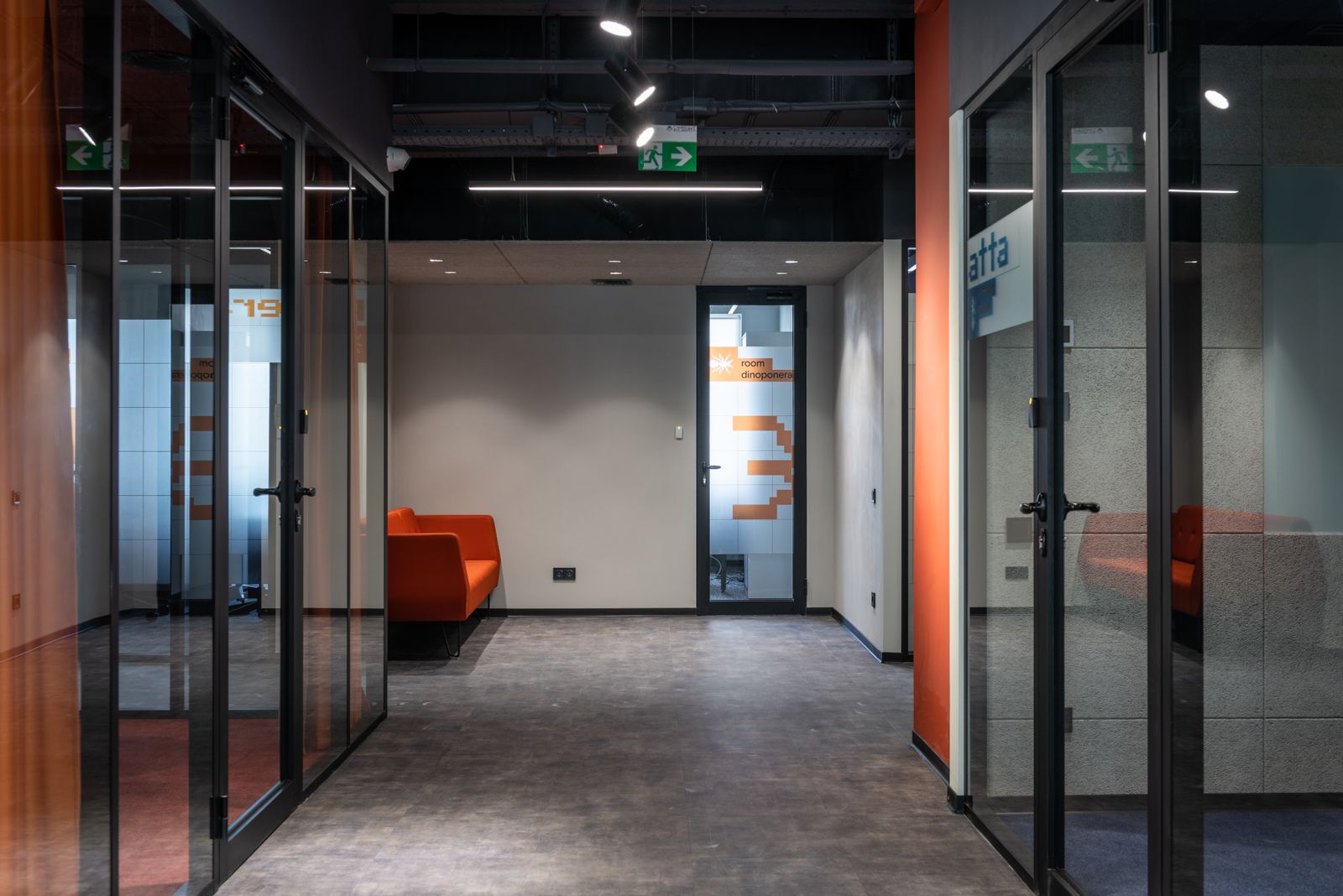 A modern office corridor with glass partitions and bright, even lighting