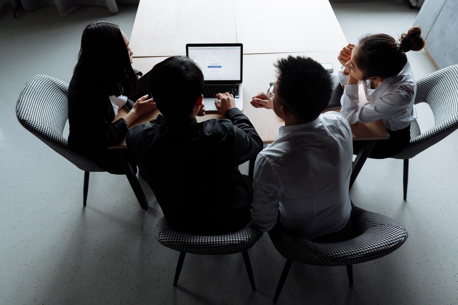 Overhead view of a team collaborating around a laptop at a shared table