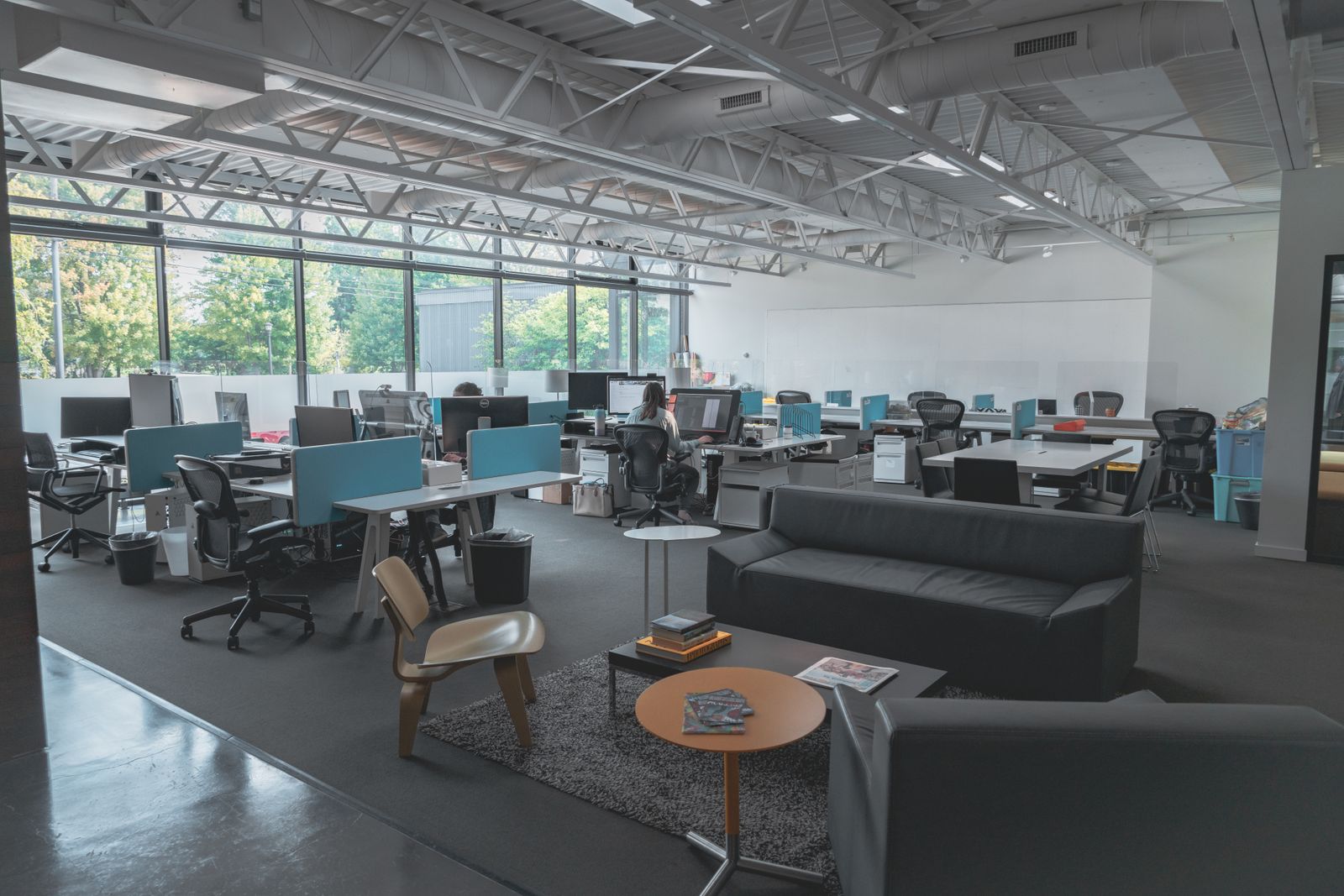 Spacious modern office interior with desks, computers, and natural light
