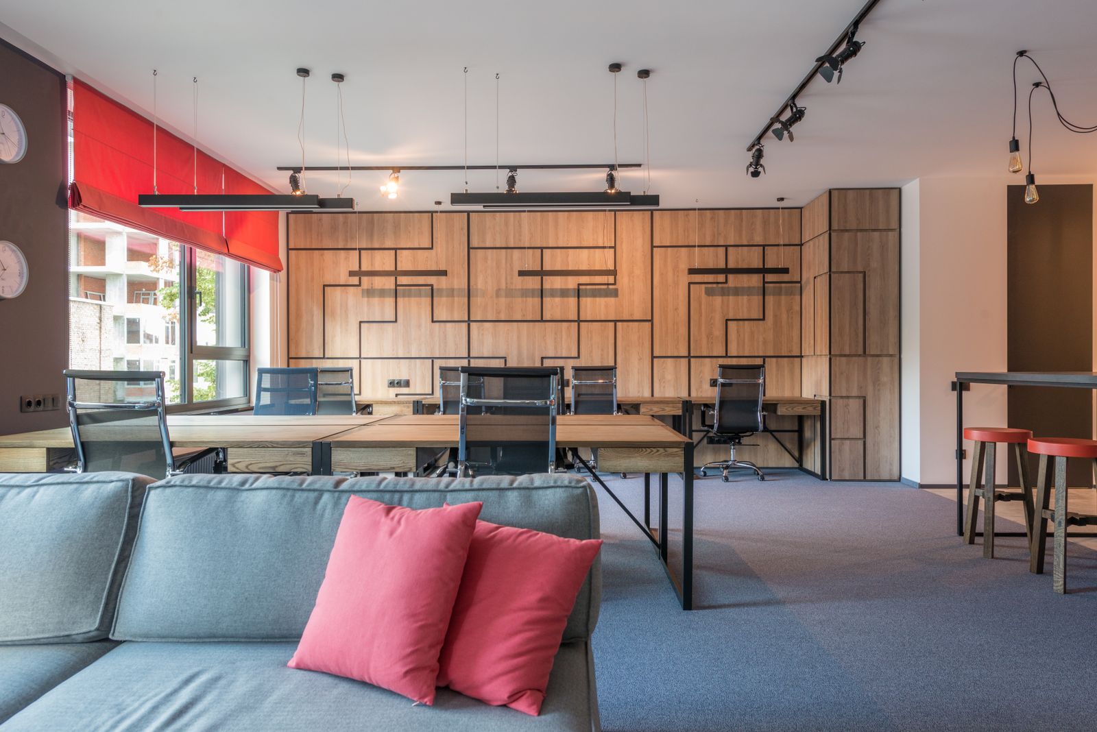Open coworking area with wooden furniture lit by daylight and open hot desks