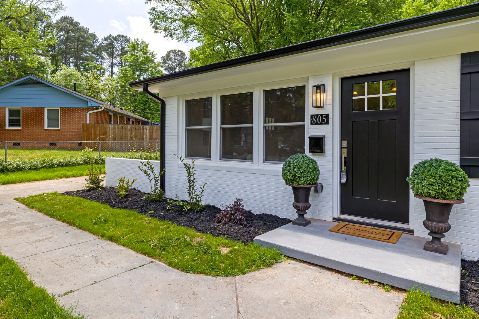 Front exterior of a family home with a rebuilt porch and landscaped yard