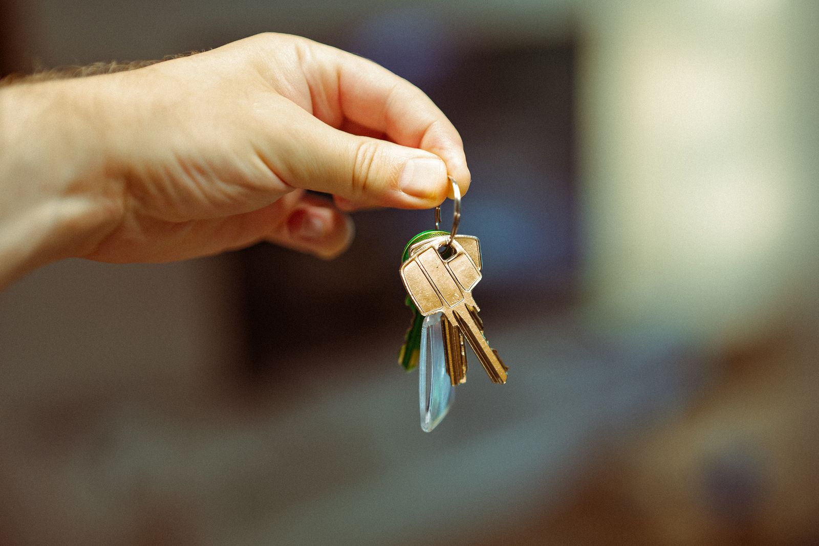 A hand holding a set of keys to a new house