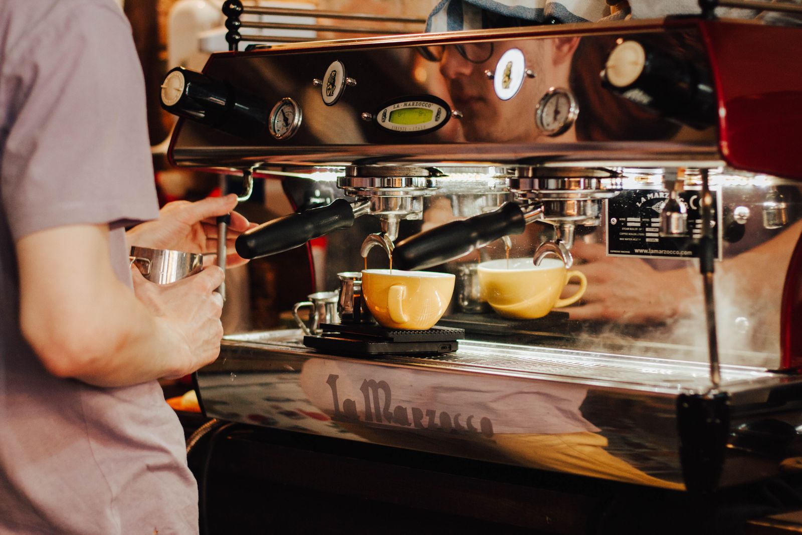 A barista pulling a shot on the espresso machine in the Grindstone café