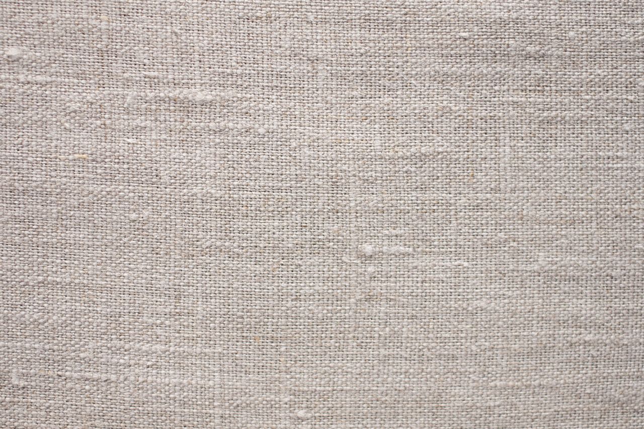 Close-up of woven beige-brown linen fabric showing natural weave texture