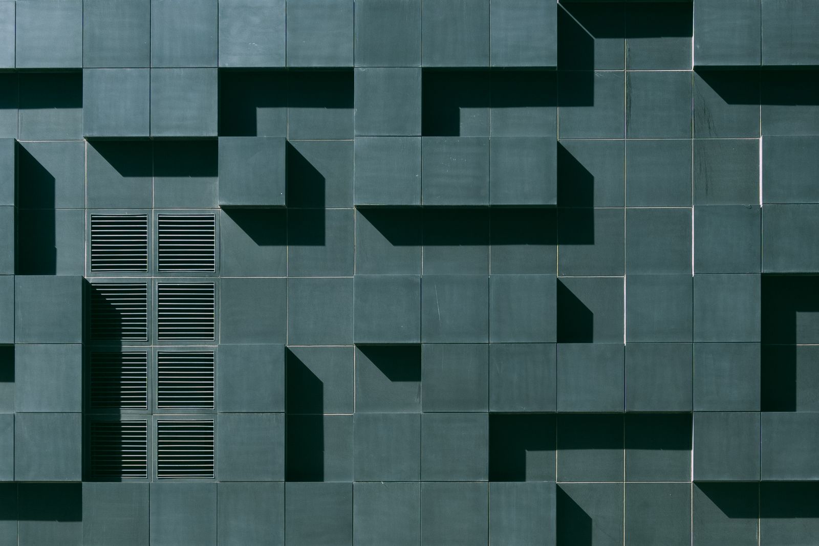 Gray concrete building exterior with bold geometric architectural design