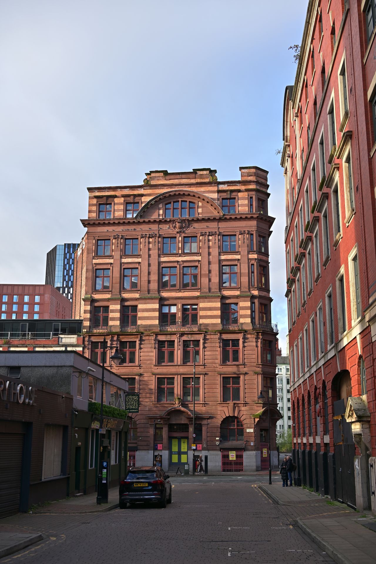 Historic red brick building with classic architectural details on a quiet urban street