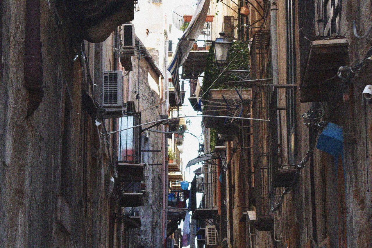 Narrow alleyway between old buildings with hanging balconies in a historic European city