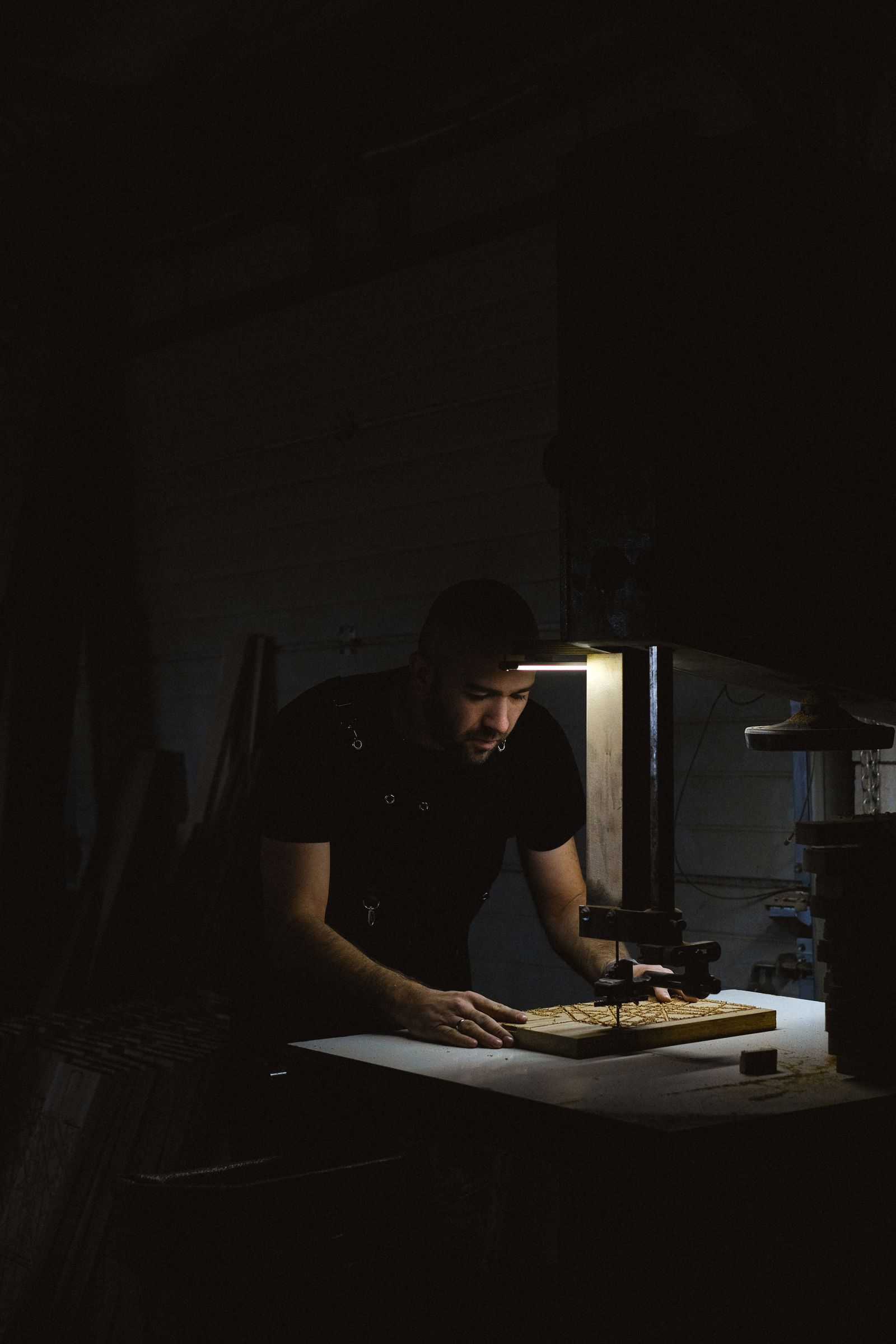 A craftsman's hands shaping a wooden piece at a woodworking bench